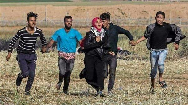 صورة بالف معنى.. شبان غزة يشكلون حاجزا بشريا لحماية حرائرهم