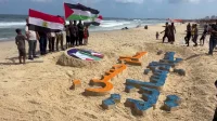 فنان فلسطيني من ذوي الاعاقة يرسم لوحة وفاء للمدرب حسام حسن على رمال غزة