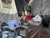 طفل فلسطيني يتحدى واقع الخيام باعادة بناء منازل غزة المدمرة بالكرتون